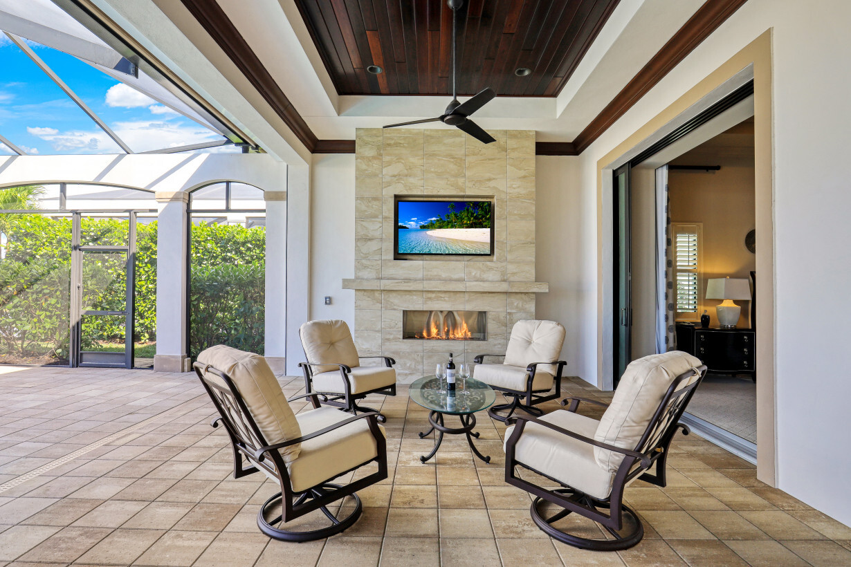  Motorized Storm Shutters protect all the covered seating, including the TV and Natural gas Fireplace area | 16459 Seneca Way – Naples, Florida 34110 - Listed By Janine Monfort - Naples, Florida Real Estate Agent at Premier Sotheby's International Realty